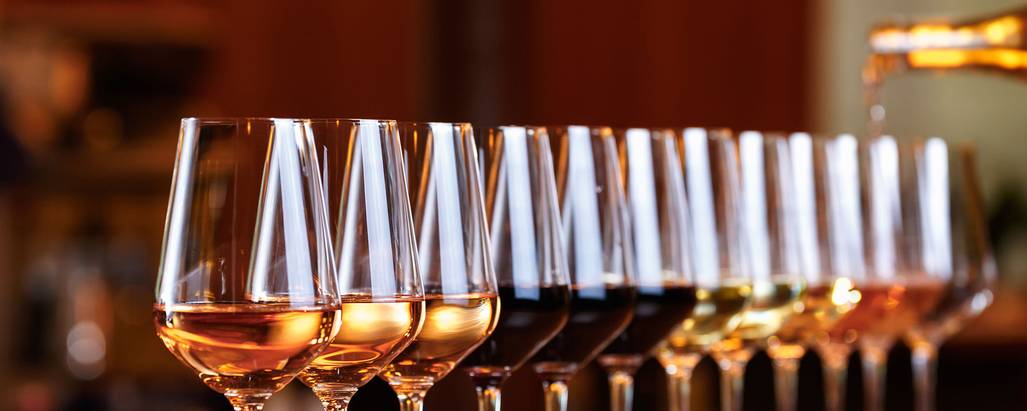 wine glasses, lined up with different types of wine